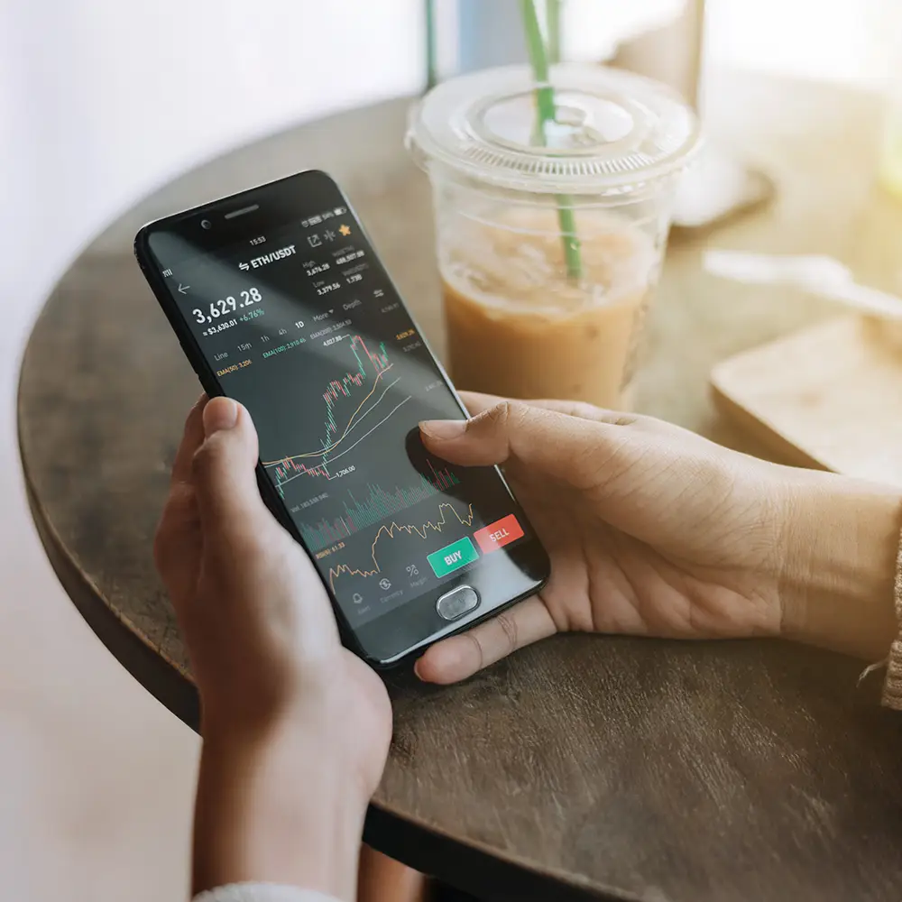 Person analysing cryptocurrency market charts on a mobile trading app.