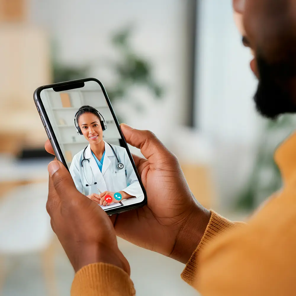 Person holding a smartphone during a video consultation with a female doctor.