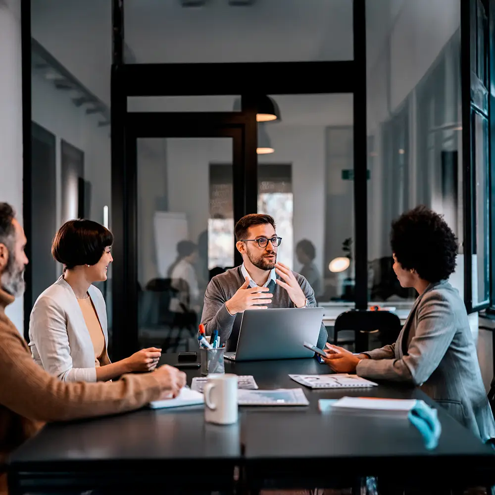 Team meeting in a modern office with professionals discussing a project around a table