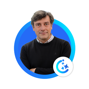 Portrait of a man in a dark jumper with folded arms inside a blue circular frame.